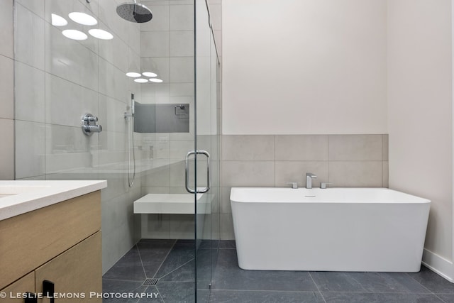 bathroom featuring independent shower and bath, vanity, and tile walls