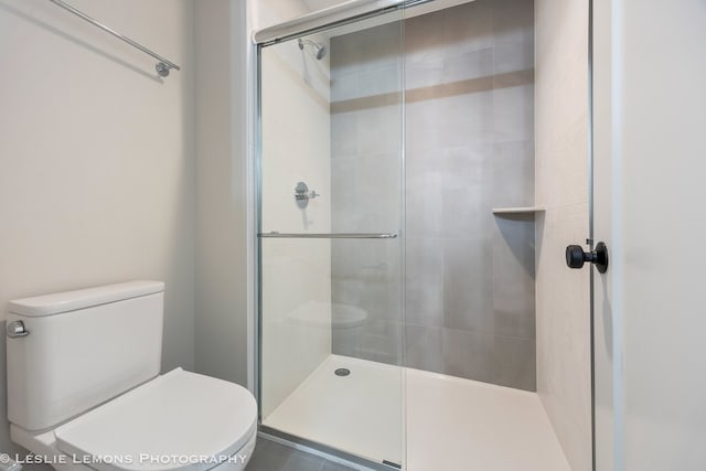 bathroom featuring walk in shower and toilet