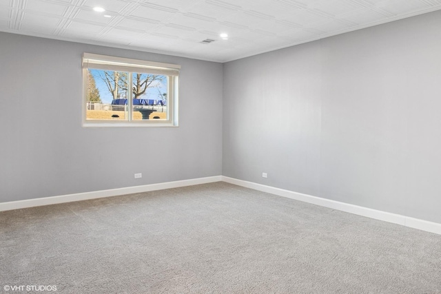 empty room with carpet flooring, an ornate ceiling, and baseboards