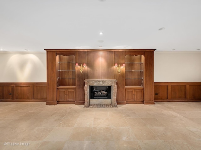 unfurnished living room featuring crown molding and a high end fireplace