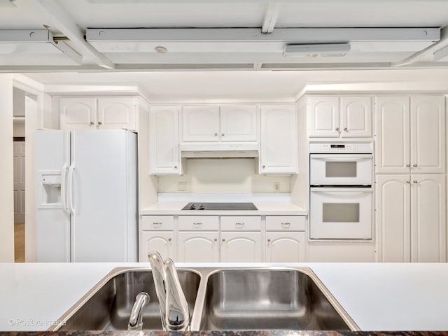 kitchen with white cabinetry, sink, and white appliances