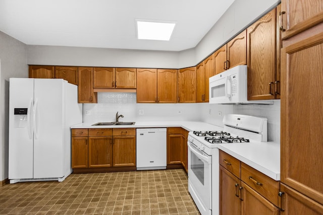 kitchen featuring sink, white appliances, and tasteful backsplash