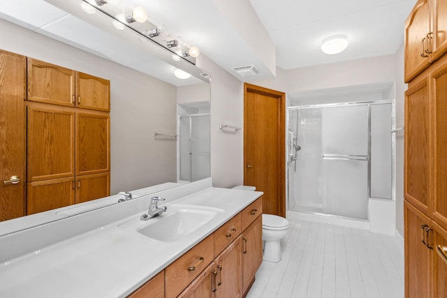 bathroom with toilet, vanity, tile patterned flooring, and an enclosed shower