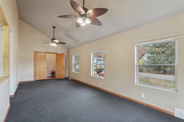 unfurnished room with dark colored carpet and vaulted ceiling