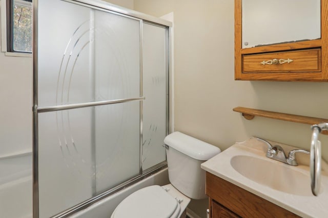 full bathroom featuring vanity, enclosed tub / shower combo, and toilet