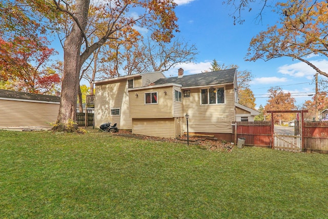 rear view of house featuring a lawn