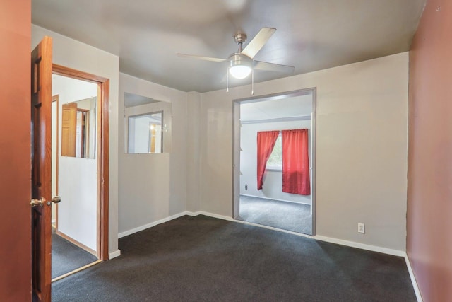 unfurnished room with ceiling fan and dark colored carpet