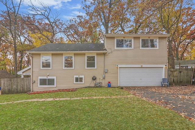 rear view of house with a garage and a lawn