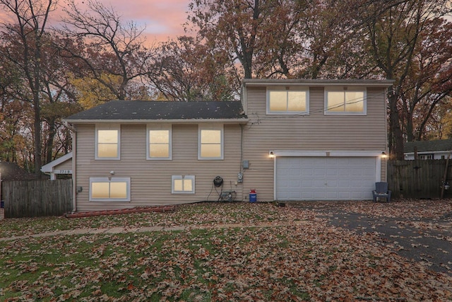 back house at dusk with a garage