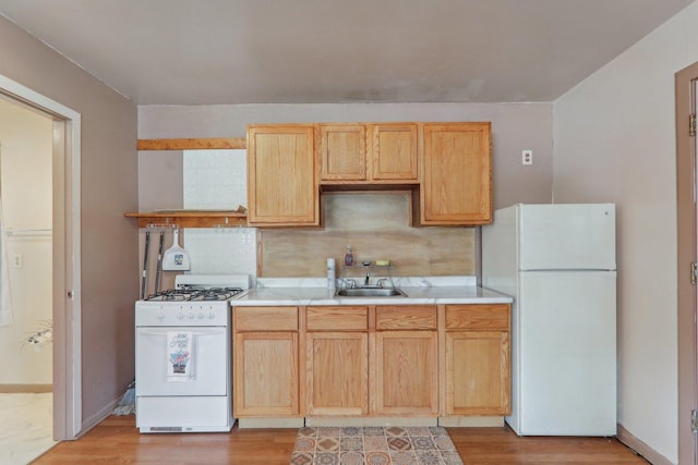 kitchen with sink, light hardwood / wood-style flooring, light brown cabinets, white appliances, and backsplash