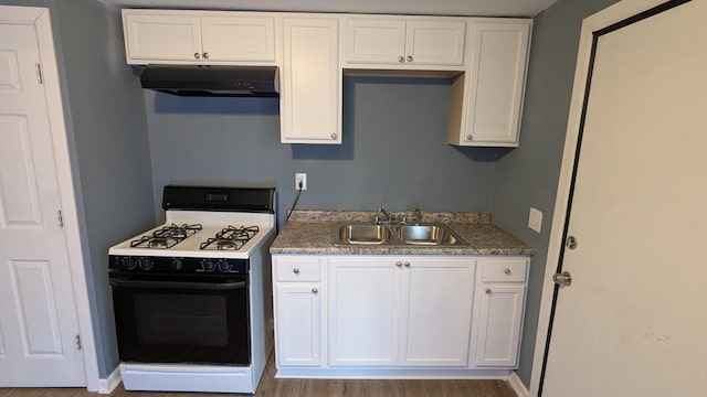 kitchen featuring sink, light stone counters, gas range oven, hardwood / wood-style floors, and white cabinets