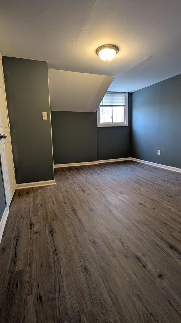 bonus room with lofted ceiling and dark hardwood / wood-style flooring