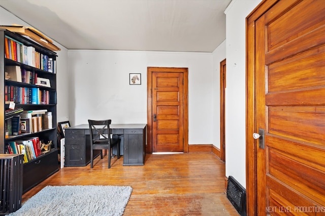 office space featuring wood finished floors, visible vents, and baseboards