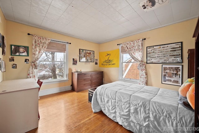 bedroom with light wood-style flooring and baseboards