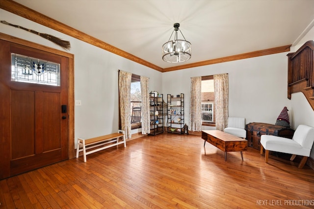 foyer entrance with radiator, ornamental molding, light wood-type flooring, and a notable chandelier