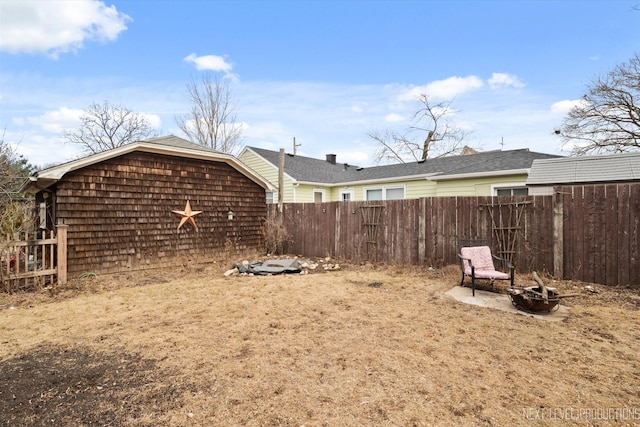 view of yard featuring fence and a fire pit