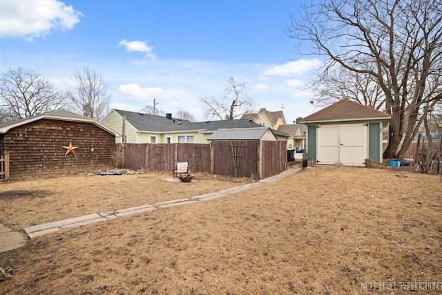 view of yard featuring an outdoor structure, fence, and a storage unit