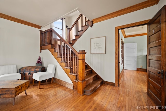 stairway with ornamental molding, hardwood / wood-style floors, and baseboards