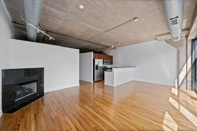 1150 W 15th St Unit 232, Chicago, IL 60608 - unfurnished living room featuring a tiled fireplace and light hardwood / wood-style floors