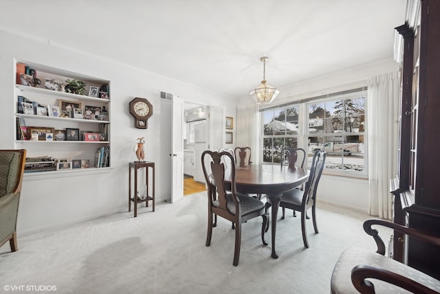 267 Merton Ave, Glen Ellyn, IL 60137 - dining room with light colored carpet, a chandelier, ornamental molding, and baseboards