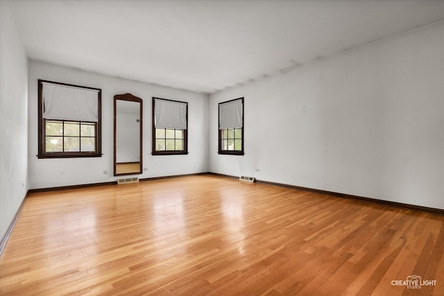 empty room featuring light wood finished floors and baseboards