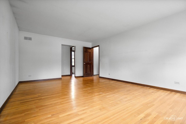 unfurnished room with light wood-type flooring and baseboards