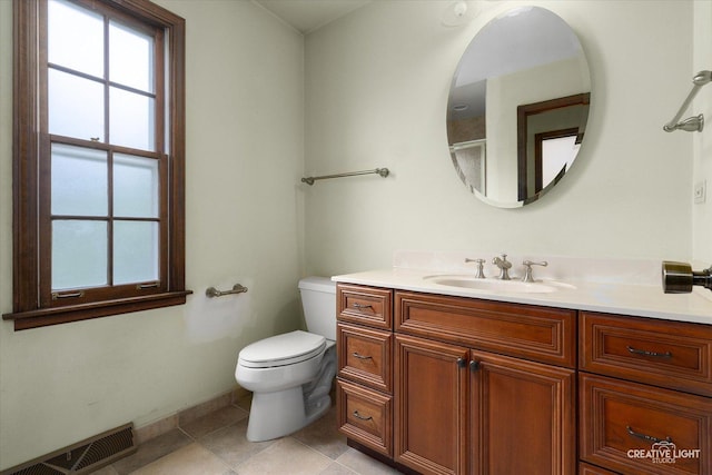 bathroom featuring toilet, vanity, plenty of natural light, and tile patterned flooring