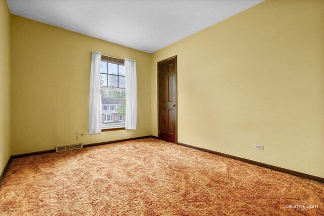 empty room featuring carpet flooring and baseboards