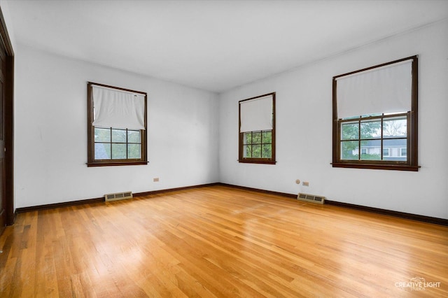 empty room featuring light wood-type flooring and baseboards