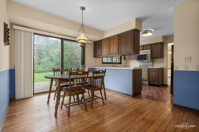 dining area with wallpapered walls and hardwood / wood-style floors