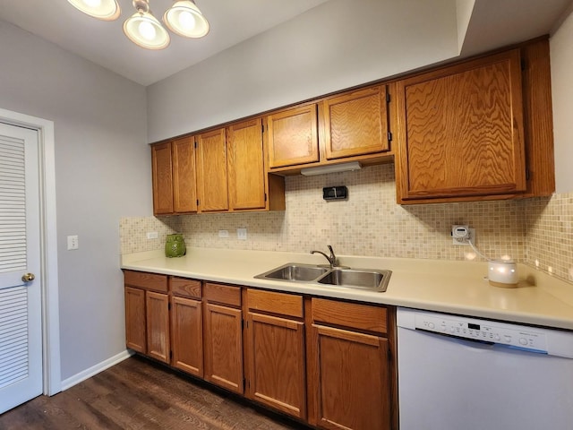 kitchen with brown cabinets, light countertops, dishwasher, and a sink