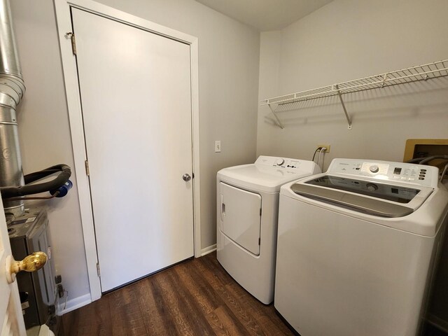 clothes washing area featuring dark wood-style floors, laundry area, and washing machine and dryer