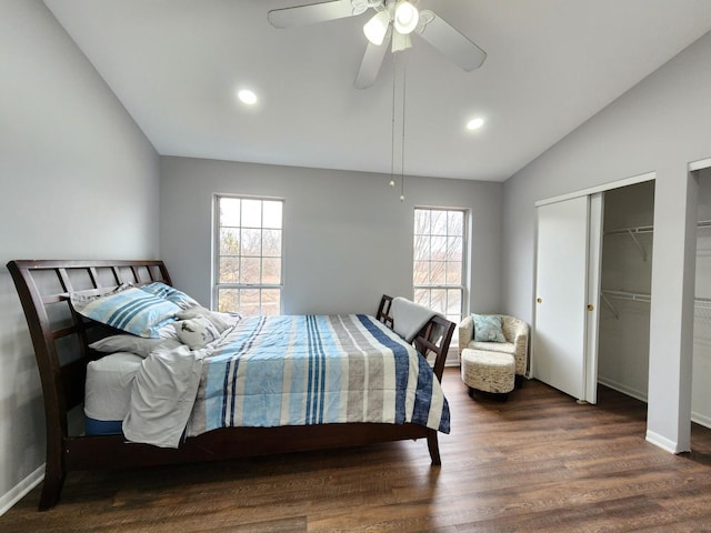 bedroom featuring multiple windows, baseboards, vaulted ceiling, and wood finished floors