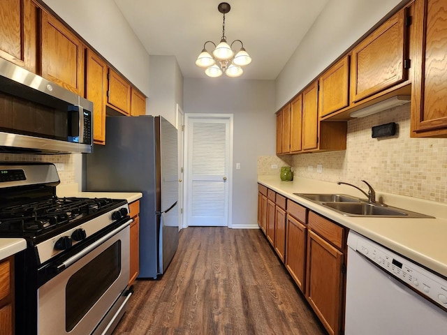 kitchen featuring appliances with stainless steel finishes, light countertops, brown cabinets, and a sink