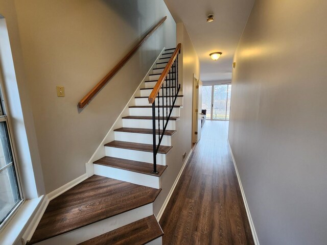 stairs featuring wood finished floors and baseboards