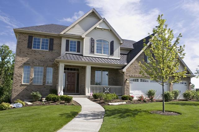 view of front of property with a porch, a garage, and a front lawn