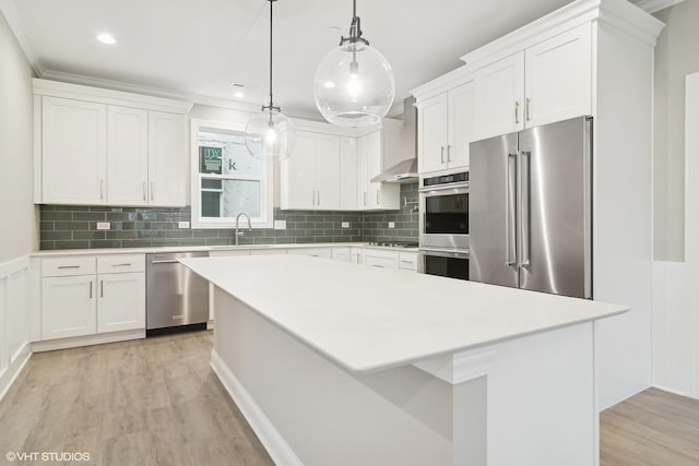 kitchen featuring white cabinetry, appliances with stainless steel finishes, a center island, and pendant lighting