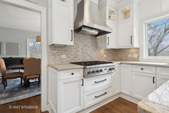 kitchen featuring stainless steel gas stovetop, tasteful backsplash, island range hood, and white cabinets