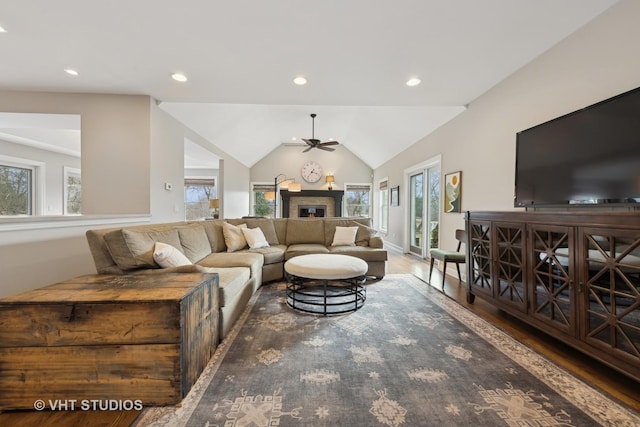 living room featuring ceiling fan, plenty of natural light, dark hardwood / wood-style floors, and vaulted ceiling