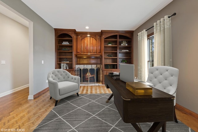 sitting room featuring parquet floors, a fireplace, and built in shelves