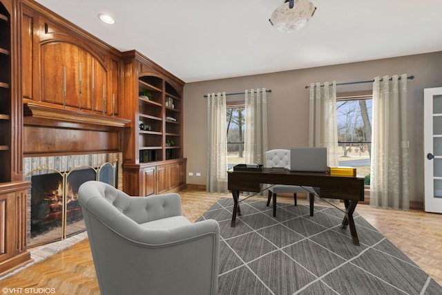 home office featuring parquet floors, a fireplace, and built in features