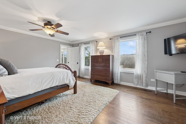 bedroom featuring crown molding, dark wood-type flooring, and ceiling fan