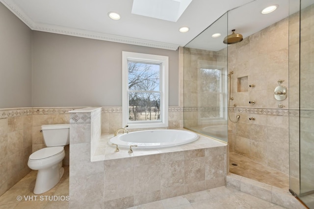 bathroom featuring toilet, shower with separate bathtub, a skylight, tile walls, and tile patterned flooring