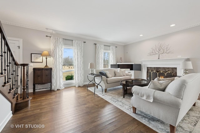 living room featuring a high end fireplace, ornamental molding, and dark hardwood / wood-style floors