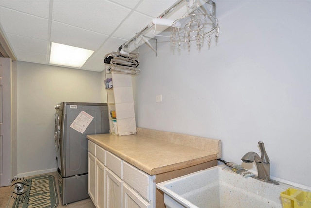 washroom with cabinet space, a sink, and baseboards