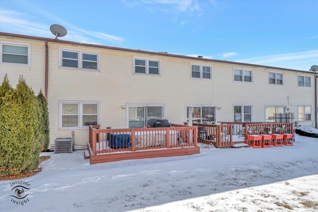 snow covered back of property featuring a deck and central air condition unit