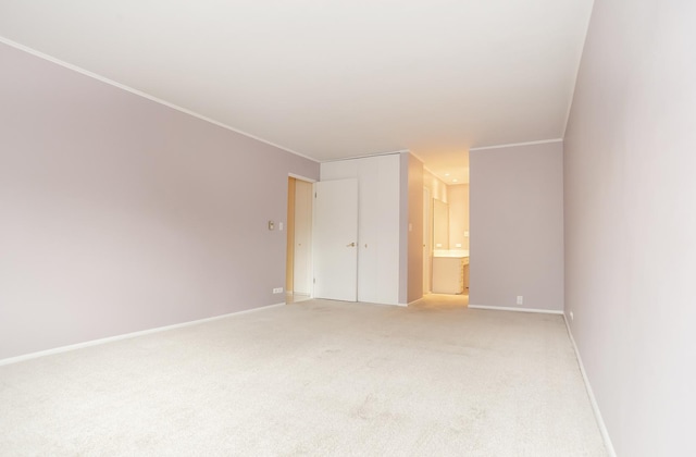 unfurnished bedroom with crown molding, carpet floors, and ensuite bath