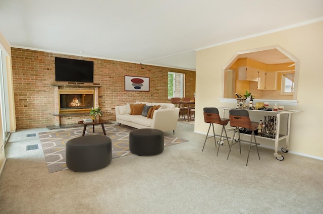 living room with light colored carpet, ornamental molding, a fireplace, and brick wall