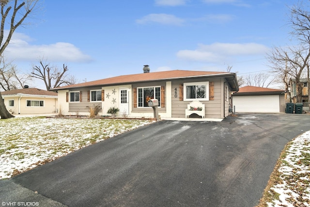 single story home featuring a garage and an outbuilding