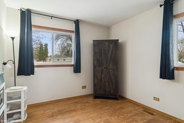 unfurnished room with hardwood / wood-style flooring